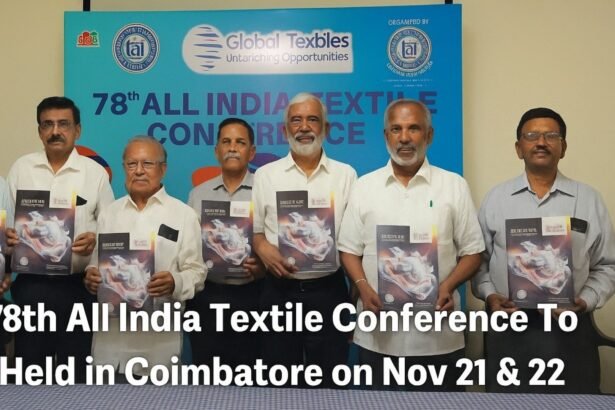 Group of textile industry leaders unveiling the brochure for the 78th All India Textile Conference in Coimbatore, standing in front of a blue event backdrop.
